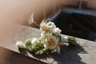 bridal bouquet laying on stone wall
