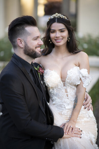 A stylish bride and groom pose in an elegant outdoor setting, coordinated by WINK! Weddings for a dream wedding experience in Florida.