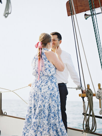 Couple embraces on sailboat during romantic Lake Michigan engagement photos

