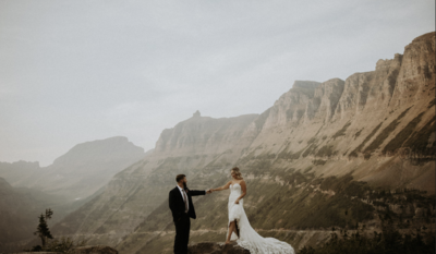 photo of bride and groom walking cliffside during elopement in montana