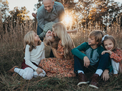 A family playing together in the field at sunset at The Vine in Acworth, GA. 