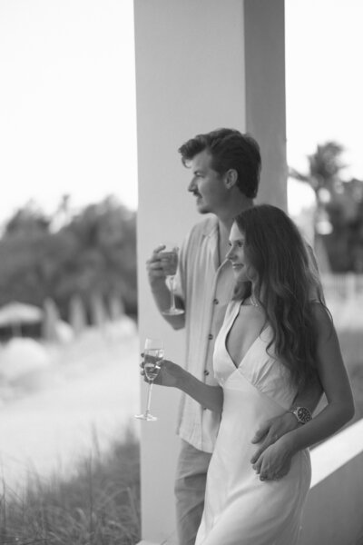 man and woman walking down the beach while holding hands