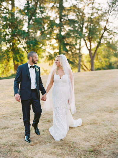 Seattle Wedding Photographers -bride and groom holding hands walking at golden hour