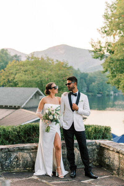 A bride and groom wearing sunglasses are posed looking at each other by an asheville wedding Photographer