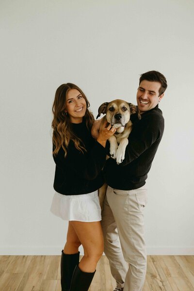 Close-up of Alberta photographer and videographer duo Hannah and Tyler holding their dog, Oakland.