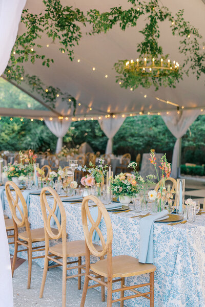 Lights twinkle and greenery hangs from chandelier over colorful tablescape during wedding reception at 255 Milledge.