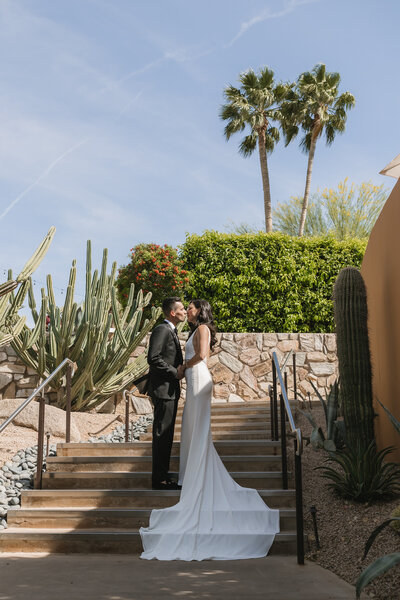 Bride and groom kiss on stairs at Sanctuary at Camelback in Paradise Valley, Arizona