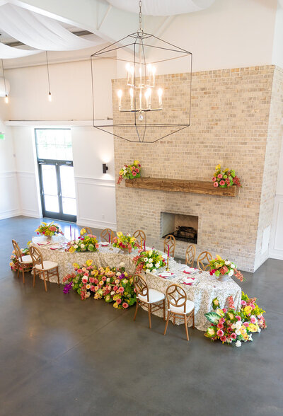 Indoor drone shot of a serpentine table scape featuring colorful florals  at The Maxwell in Raleigh, NC 