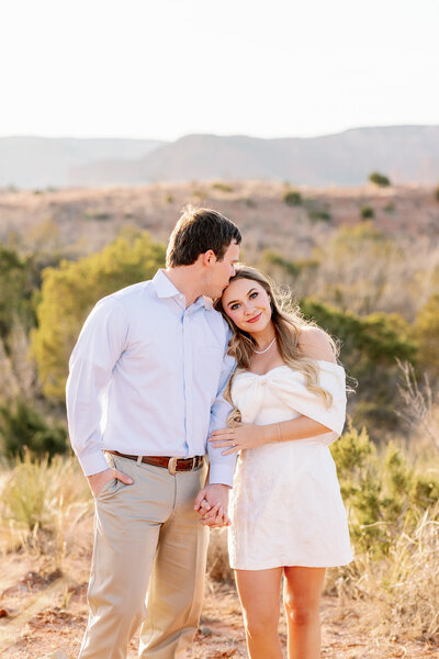 engaged woman leans on her fiance's shoulder in a romantic photo by Emily Prisk Creative