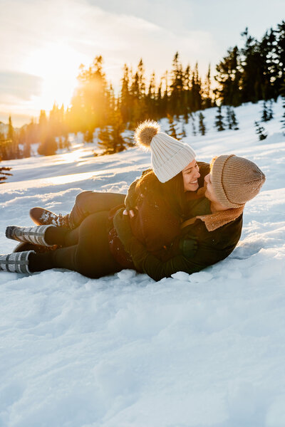 Couple playing in the snow at golden hour ,  candid couples photography session in Washington