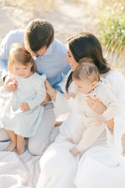 A family for 4  laughs together on the beach during their NJ Portrait photos.