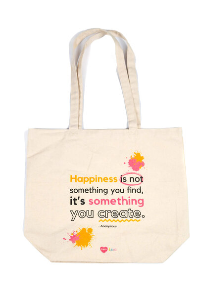 Close up shot of a canvas bag, for a product shoot for Luua in Wilton, CT. Canvas bag has "Happiness is not something you find, it's something you create" written on it.