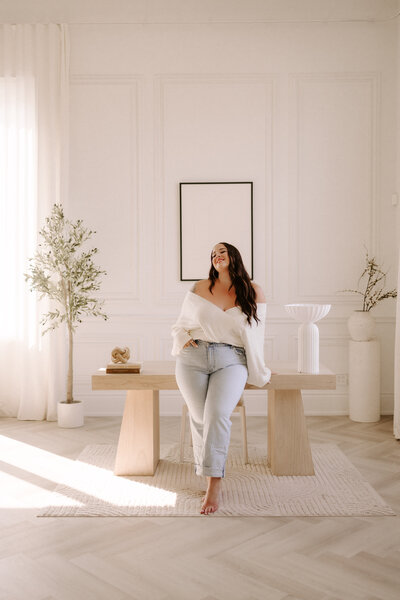 Sharlie Faye, destination weddin, and boudoir photographer in front of her desk