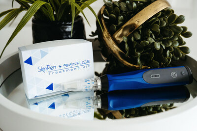 SkinPen microneedling device and serum kits styled with natural greenery