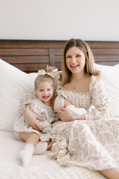 Mom holding baby while being kissed by dad in Indianapolis studio newborn session