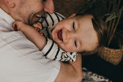 two stylish young women with contrasting hair textures stand affectionately embraced in a field of blooming yellow flowers
