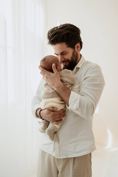 Papa en newborn tijdens newbornshoot in daglicht studio