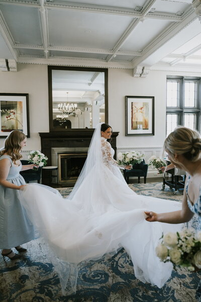 Bridal Party holding bride's dress