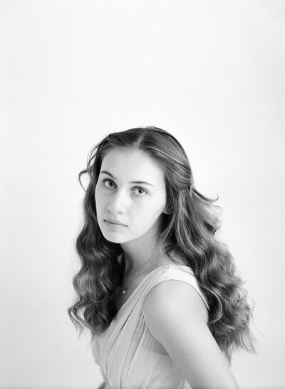 Black and white image of teen during milestone mini session in bright, neutral studio in Fisher IL