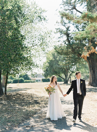A couple walking through the vineyards at their wedding in california | Drake Social Events