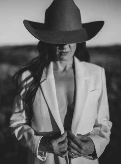 Black and white photo of Juliet Trnka wearing a beige blazer and a cowboy hat