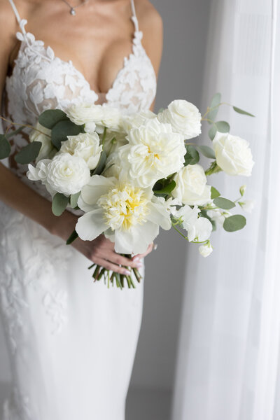 Stylish bridal bouquet with a mix of white and blush blooms, featuring anemones and cascading greenery by Leigh Florist.