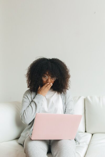 Woman boss with kinky hair standing as she looks over papers with her team.