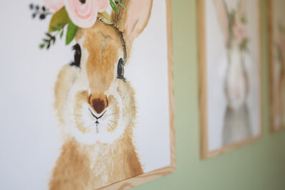 Wall print of a bunny on a sage green nursery wall.