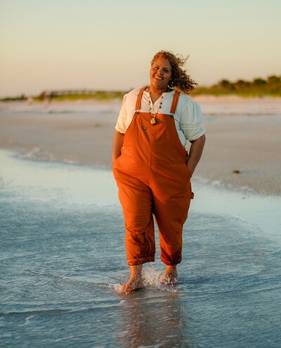 Certified life coach Claudine Martinell showing confidence and authenticity while walking barefoot on the beach.