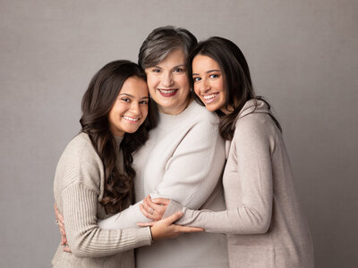 grandma and two granddaughters posing for studio portraits