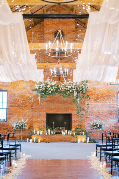 A stunning circular floral arch created by Leigh Florist, featuring white and blush flowers, creating a breathtaking focal point for the couple’s wedding ceremony.