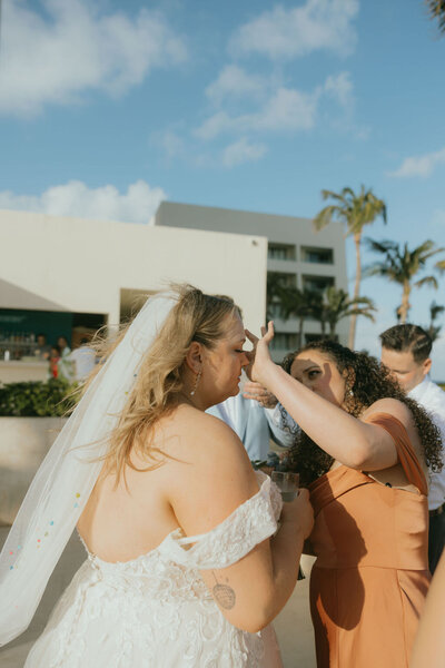 Woman helps the bride with her makeup