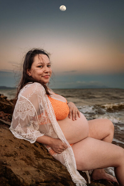 pregnant woman in white dress leading partner through a field - Townsville Maternity Photography by Jamie Simmons