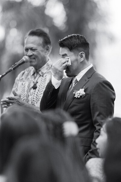 A person wiping tears from their eyes during their wedding ceremony 