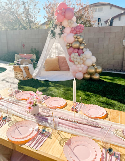 Teepee parties with balloon toppers at a backyard picnic