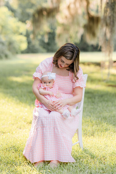 young mom and baby wearing matching outfits sitting in a chair during golden hour with Constance Calton photography