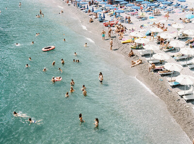 A vibrant Italian beach filled with guests, evoking joy and celebration often seen in destination wedding photography across California and DC.