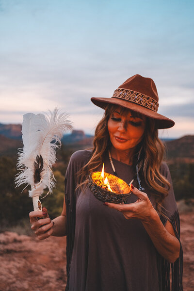 shamanic practioner Dana Haines with feather and sage in sedona, arizona promoting womens wellness retreat
