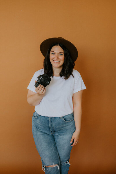 Photographer Danielle Dziedzic smiling while holding a camera