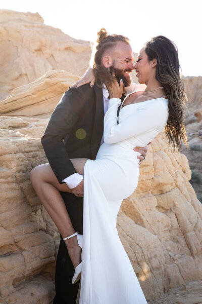 An Austin-based wedding photographer captures a heartwarming moment of a bride and groom hugging on a rock in the desert.