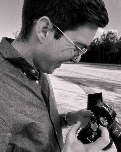 Chris holding the camera smiling while filming a wedding.