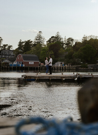Maine Engagement photography. Couple on a dock out in Maine on a summer sunset day