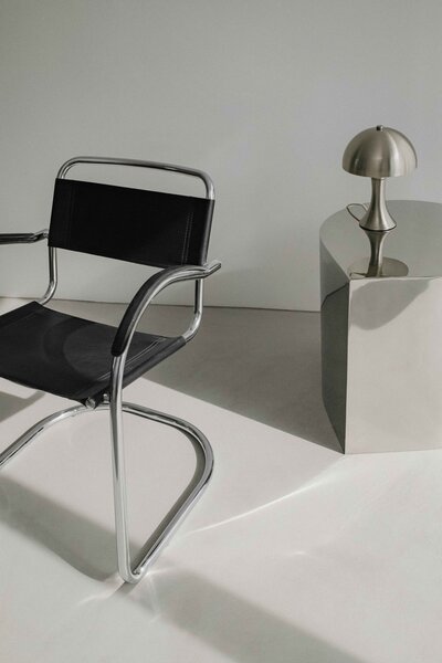 A modern design studio with a black monochromatic chair and side table