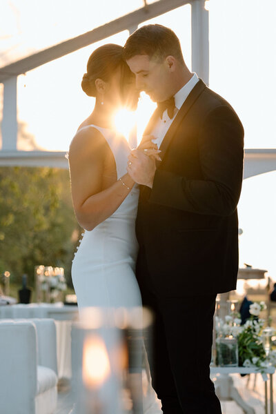 A bride and groom having their first dance at sunset in a clear top tent at Wheatfield Estate