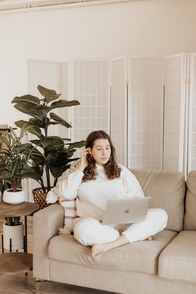 Woman sitting on the couch working on a laptop