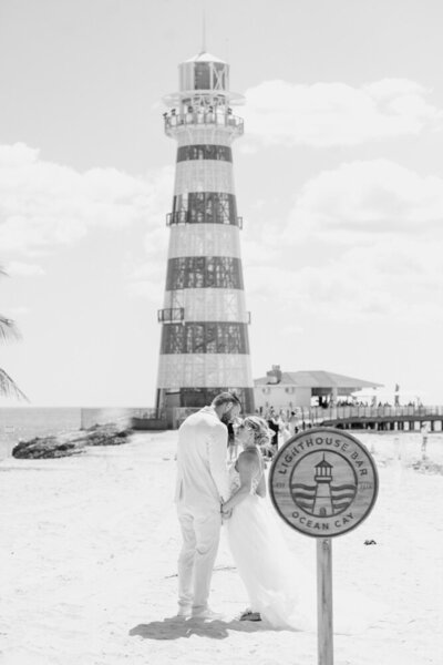 a couple by a light house at their Bahamas cruise