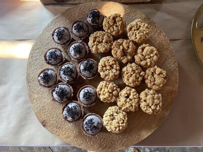 Photo shows a plate with several mini desserts. On one half are cookies and cream pies with cookie crumbs on top. On the other half are apple crumble pies.