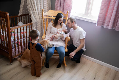 Newborn photo of baby with family taken by Photographer who photographs in places like Sugarloaf, Maine
