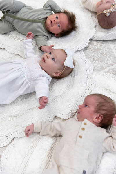 Babies laying on blankets in a circle on the floor