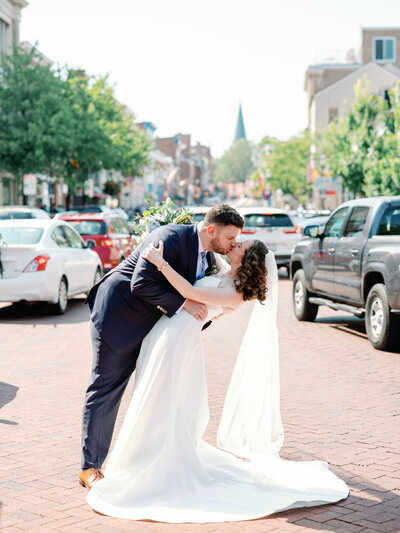 Bride and groom kissing in downtown historic street